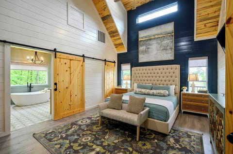 Your master bedroom's striking navy accent wall and rustic barn door create a perfect blend of modern elegance and cozy charm.