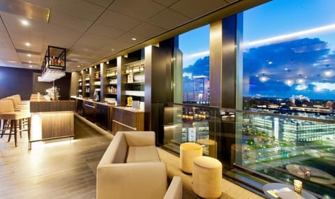 Unwind with cocktails as city lights sparkle beyond windows.