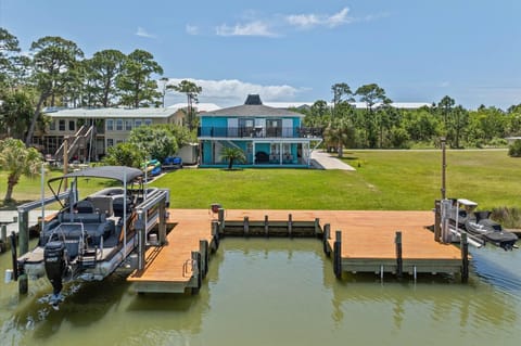 Waterfront property with private dock and boat access, surrounded by lush coastal landscape and neighboring homes.
