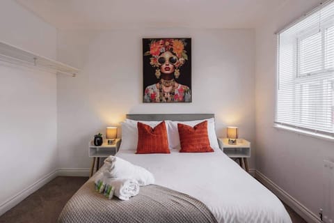 Cozy bedroom with vibrant artwork, soft lighting, and plush bedding