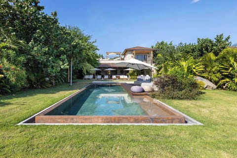  A beautifully designed pool area featuring crystal-clear water, lush surroundings, and plenty of seating for relaxation