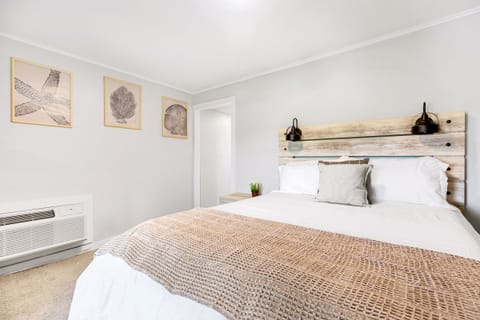 Comfortable queen size bed in a large bedroom with natural light