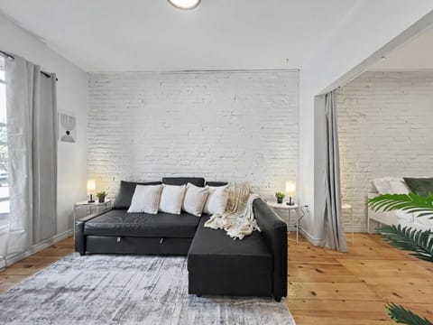 Relax in style! Our airy living room blends rustic brick charm with modern comfort—the perfect spot for movie night.
