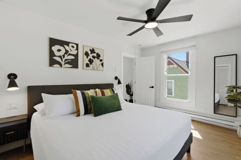 Bright and airy bedroom with natural light, ceiling fan, and stylish decor.