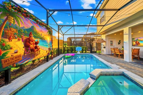 Screen-enclosed private pool and hot tub with outdoor movie theater, dining area, lounge space, pool games, accent lighting, smart TV