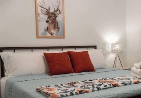 King bed in the main room with deer decor for our backyard friends!