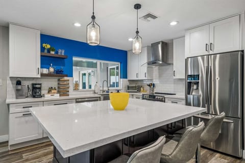 Stainless steel appliances, large island, countertop seating for 3, drip coffee and keurig coffee, toaster oven, and kitchen essentials.
