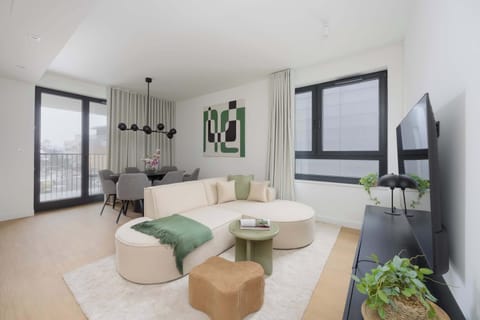 Bright and modern living area with a comfortable sofa, elegant coffee table, and large windows bringing in plenty of natural light.