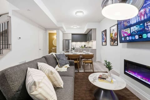 Modern living room with cozy seating, Smart TV, and sleek fireplace ambiance