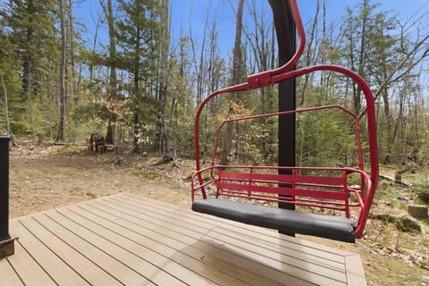 The fire-engine-red restored ski lift chair mounted on the back deck — the most-photographed spot at the chalet.