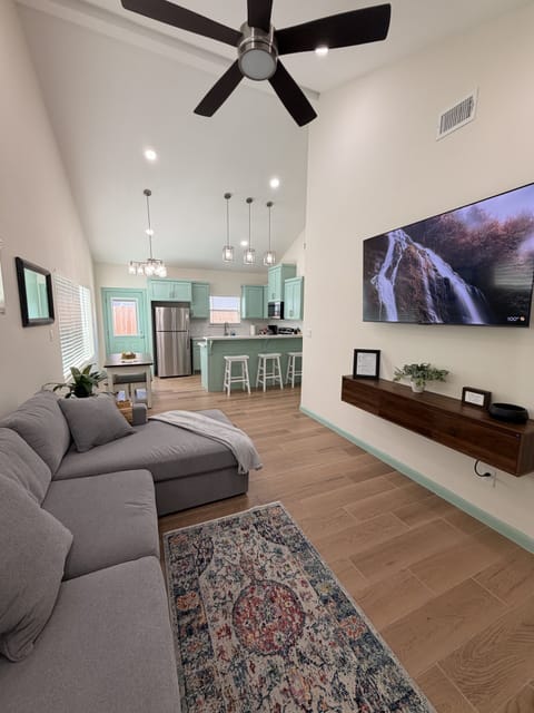 Bright open living space with vaulted ceilings, smart TV, and stylish kitchen