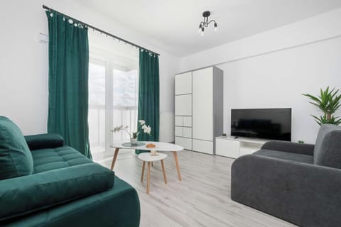A bedroom with a sofa seating area and TV. The space is comfortable and functional.