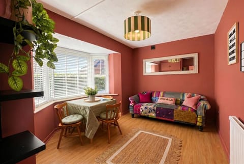 Bold patchwork sofa and bay window make this living room impossible to forget.