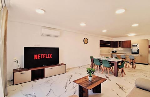 Open plan living room and dining/kitchen area, with AC and Smart TV for a comfortable stay.