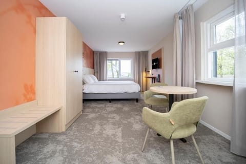 Unwind in a spacious suite with cozy seating and daylight.