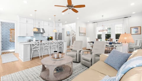 Step into your bright, airy coastal retreat where the open-concept living space flows effortlessly from the modern kitchen to the cozy living area.