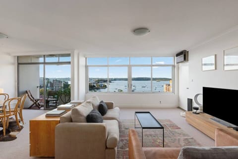 Stretch out in the light-filled living area where sweeping harbour views and relaxed coastal styling create an effortless backdrop for slow afternoons above Elizabeth Bay.