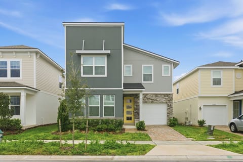 Experience a warm welcome with our beautiful two-tone exterior featuring dark siding and rustic stone accents. The charming yellow door beckons you to explore our thoughtfully designed spaces and inviting landscaping that feels.