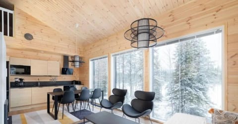 The open-plan living area features large floor-to-ceiling windows, allowing you to enjoy the snowy fell views and natural light while dining or relaxing.