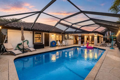 Unwind beneath glowing sunset skies in your private screened-in pool oasis—perfect for day-to-night relaxation.