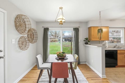 Dine with a view! This bright dining area features mid-century modern seating and unique woven wall decor, all set against a sliding glass door that opens to the backyard. It’s a cheerful, sun-drenched spot for family meals and morning coffee.