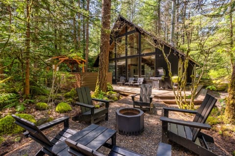 Deck with fire pit seating under the trees.