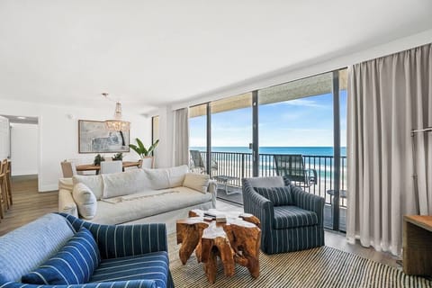 Unwind in your bright, coastal living space where floor-to-ceiling windows frame stunning turquoise ocean views. Plush seating and natural textures invite you to relax by the sea.