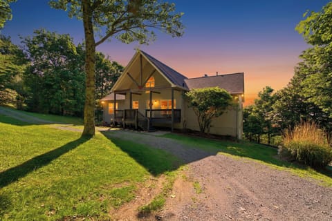 Charming wooded cabin at sunset with a private drive and cozy front porch