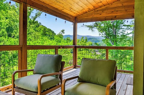 A cozy outdoor seating area overlooking mountain views and lush green trees.