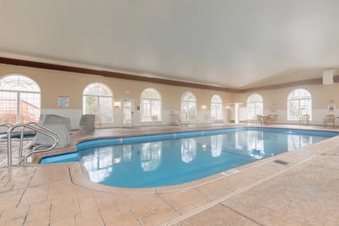Indoor pool with arched windows and spacious seating area.