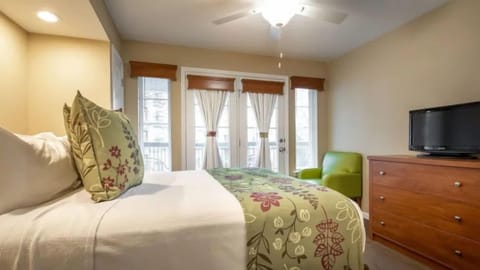 King-size bedroom with balcony access and warm lighting.