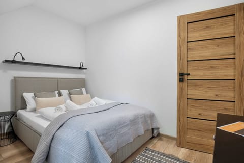A cozy bedroom with a double bed, wooden door, and soft neutral décor creating a relaxing atmosphere.