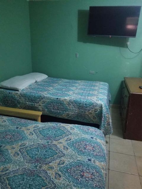 ground-floor studio features a queen-size bed with air conditioning, a small sitting area, and an equipped kitchenette