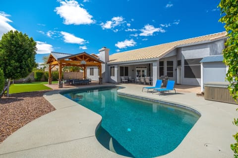 Private backyard oasis featuring a sparkling pool, and covered patio with outdoor seating—ideal for relaxing under sunny Arizona skies.
