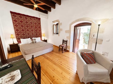 Bright bedroom with a comfortable bed, exposed wooden beams, and wooden furnishings, creating a warm and authentic atmosphere.
