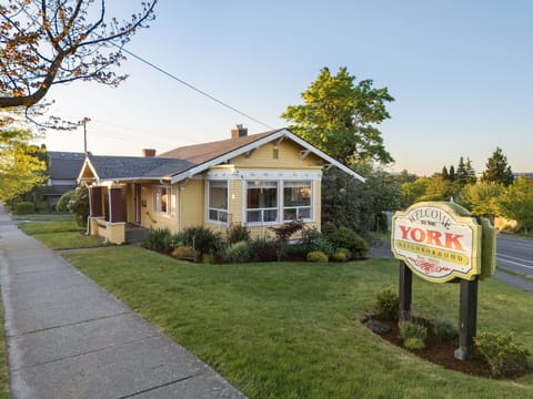 Charming yellow craftsman cottage welcomes travelers to the peaceful York Neighborhood.