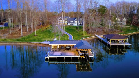 Backyard - The home sits up the slope from the waterfront, with the dock, sandy beach, and boathouse spread out below.
