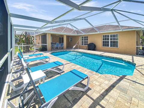 Private pool with sun loungers and screened enclosure for ultimate relaxation.