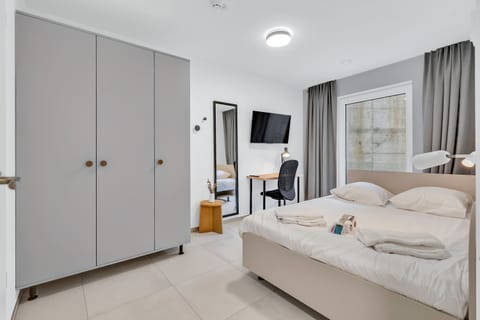 Bright bedroom with spacious wardrobe and comfortable bed for a restful stay.