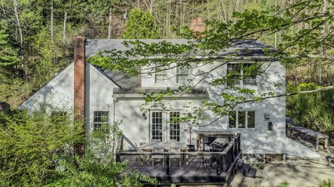 Classic New England charm with a spacious deck, outdoor dining, and views of the wooded hillside