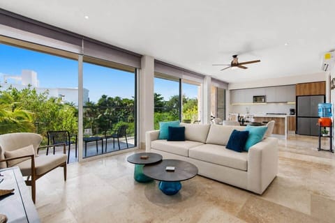 Bright open-concept living room with a comfy couch and direct access to your private balcony with outdoor furniture, perfect for enjoying the views and sea breezes. Includes A/C, ceiling fan, room-darkening shades, and filtered drinking water.