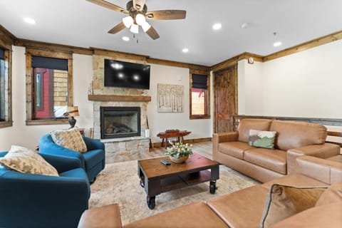 Relax in your spacious living area with warm wood accents, natural light flooding through large windows, and cozy seating perfect for unwinding after a day of adventure.