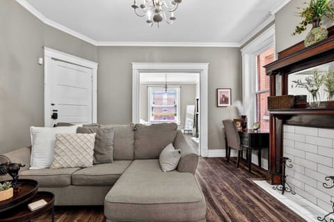 Living Room: Spacious living room featuring a cozy sofa, hardwood floors, and curated decor — the perfect spot to unwind after a long day of travel