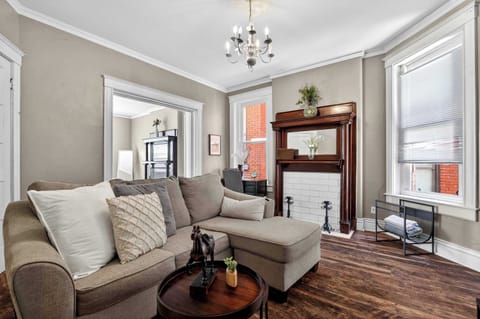 Living Room: Spacious living room featuring a cozy sofa, hardwood floors, and curated decor — the perfect spot to unwind after a long day of travel