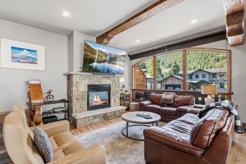 Spacious living room with plenty of seating, smart TV, fireplace, and huge windows
