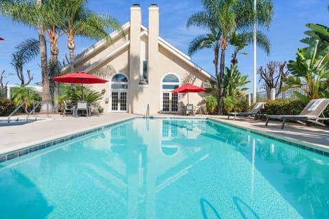 Dive into sunlit relaxation beside sparkling resort-style pool.