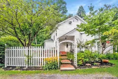 Picturesque white picket fence framing a classic country farmhouse estate.