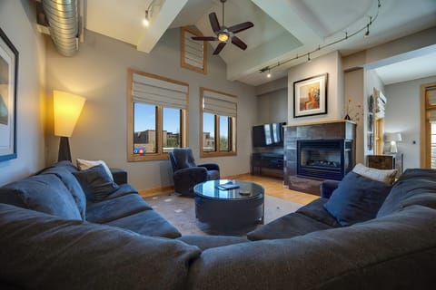 Sink into plush sofas by the fireplace and enjoy mountain views through tall windows. The vaulted ceiling and modern decor create a welcoming retreat where your group can relax together.