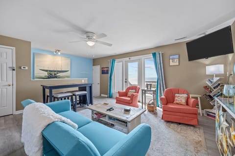 Sink into plush coastal seating while your ceiling fan keeps you cool. The open layout flows perfectly from living to dining areas.