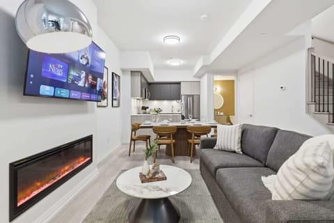 Open-concept living and dining area with Smart TV, fireplace, and modern kitchen